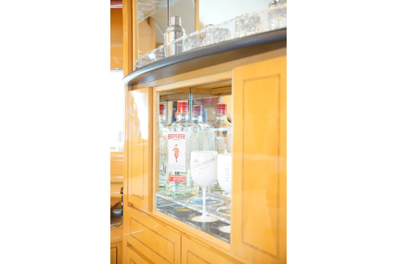  Yacht Photos Pics Bar cabinet with Beefeater gin bottles and glasses on a 1999 Mangusta 80 yacht.