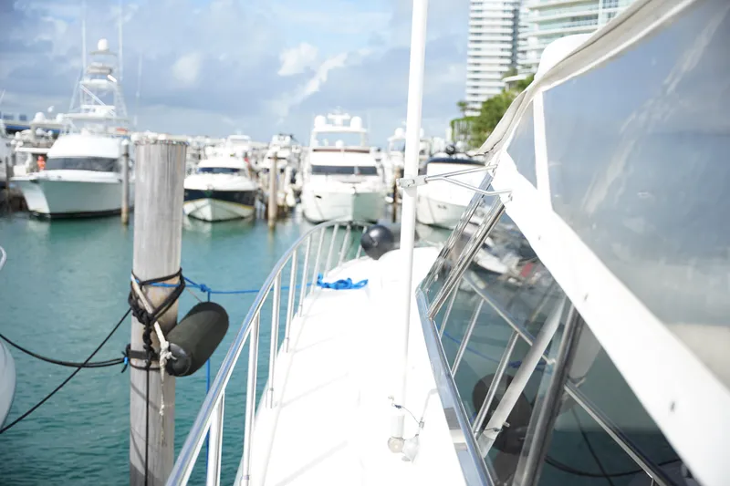  Yacht Photos Pics 1999 Mangusta 80 yacht docked in a marina with other boats.