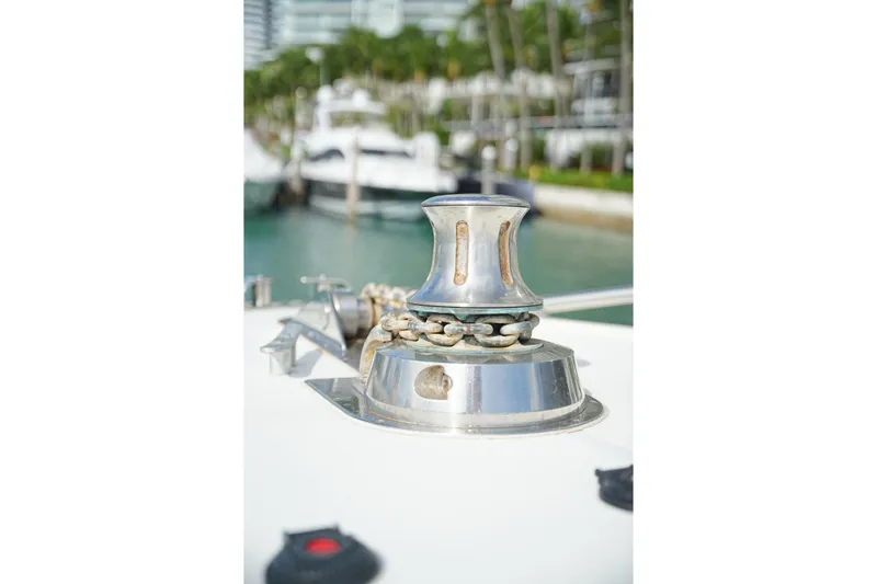  Yacht Photos Pics Close-up of a 1999 Mangusta 80 yacht's anchor winch with marina background.