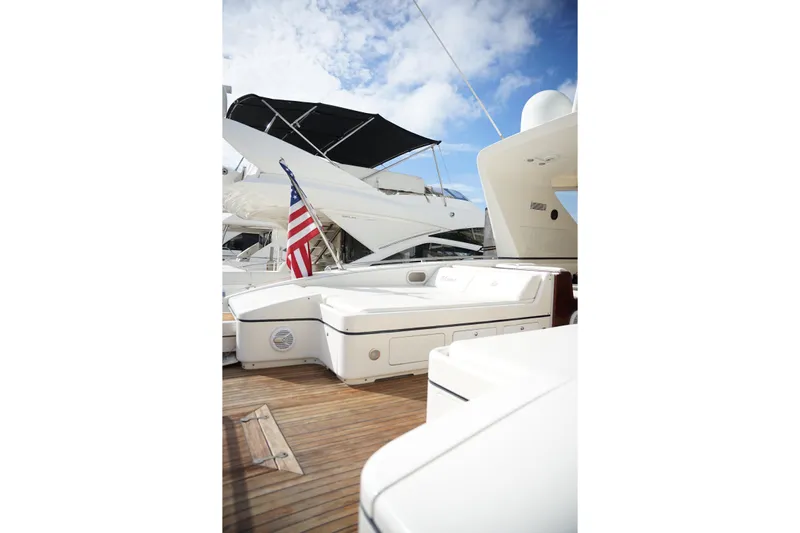 Yacht Photos Pics 1999 Mangusta 80 yacht deck with American flag, featuring sleek design and wooden flooring.