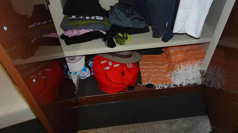 Sc Yacht Photos Pics Open cabinet in Carver C34 Coupe 2018 with clothes, hats, and bags neatly organized.