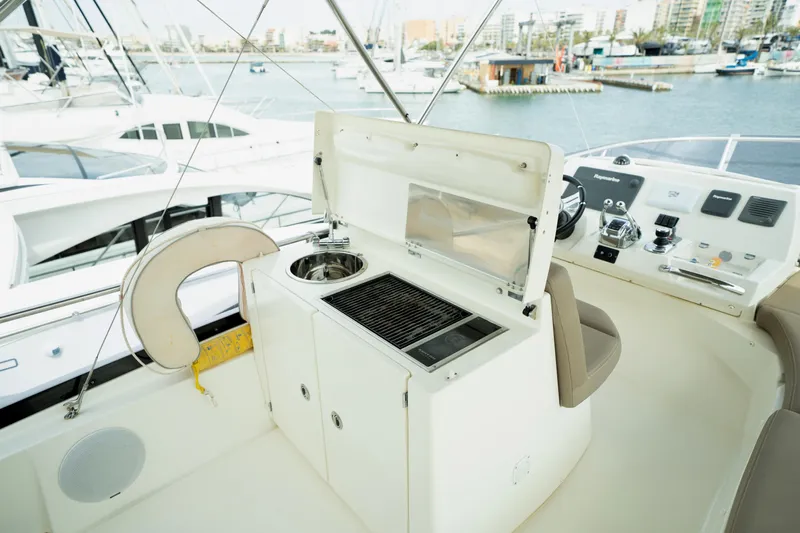  Yacht Photos Pics Flybridge of 2014 Prestige 550 yacht with grill and sink, docked at marina.