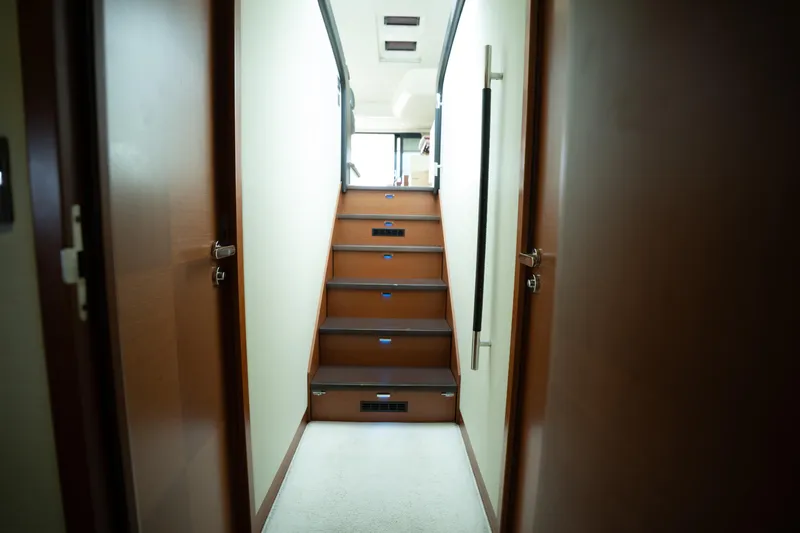  Yacht Photos Pics Interior staircase of 2014 Prestige 550 yacht, featuring wooden steps and modern design.