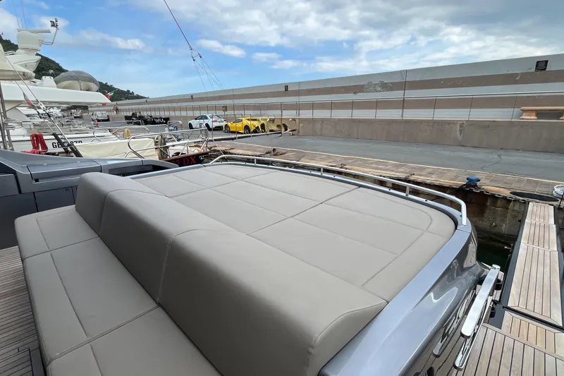  Yacht Photos Pics 2024 Pershing 8X yacht with luxurious seating at a marina, under a partly cloudy sky.