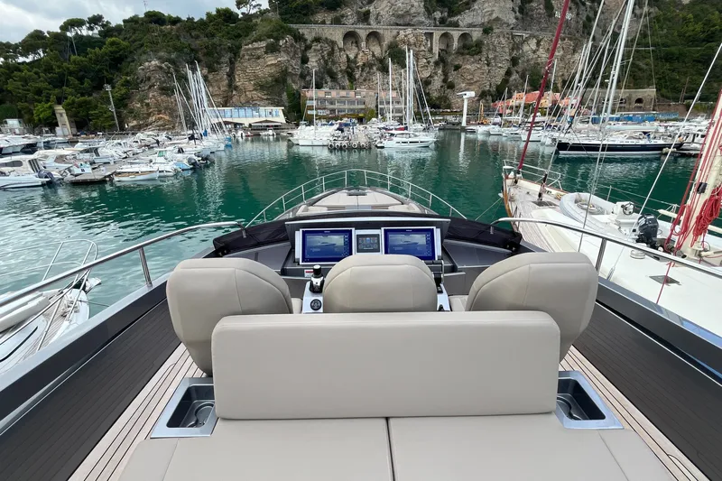  Yacht Photos Pics 2024 Pershing 8X yacht cockpit with modern controls, docked in a scenic marina.