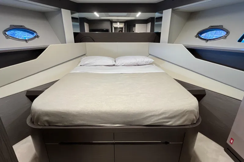  Yacht Photos Pics Luxurious bedroom interior of 2024 Pershing 8X yacht with modern design and porthole windows.