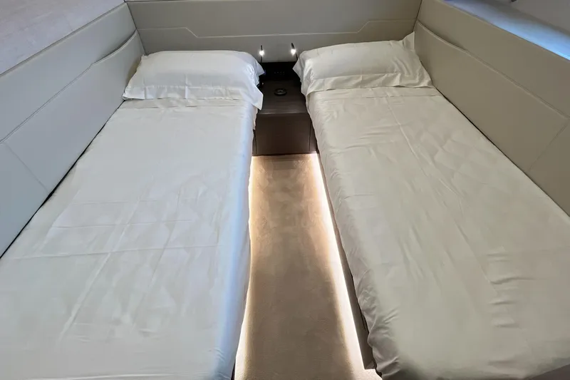  Yacht Photos Pics Twin beds in a luxurious 2024 Pershing 8X yacht cabin with ambient lighting.