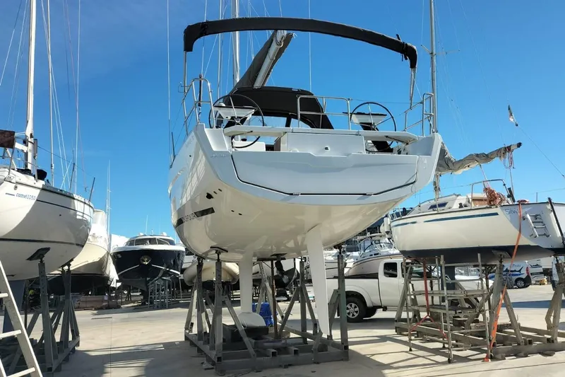  Yacht Photos Pics 2025 Dufour 37 sailboat on dry dock, surrounded by other boats under clear blue sky.