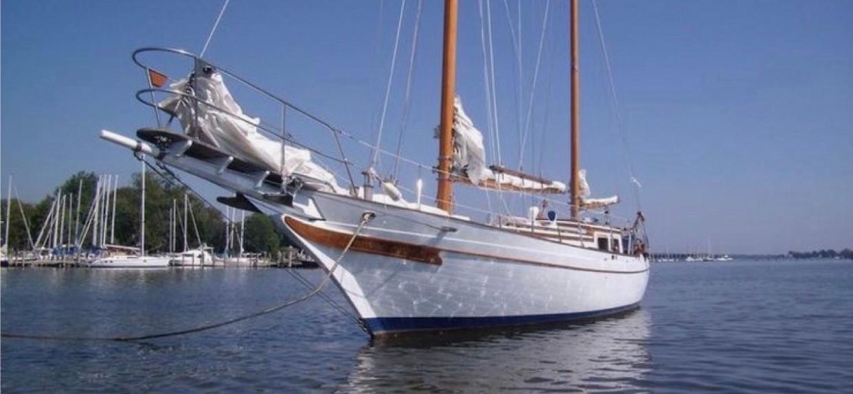 Classic 1976 CT 41 sailboat on calm water, featuring wooden masts and white hull.