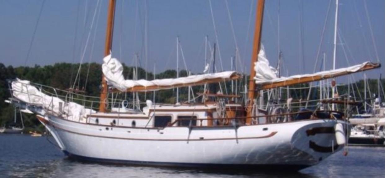 Classic 1976 CT 41 sailboat with white hull and wooden masts on calm water.