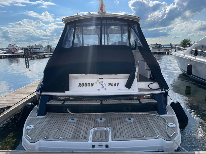  Yacht Photos Pics 2010 Regal 44 Sport Coupe docked, rear view with "Rough Play" sign, under a partly cloudy sky.