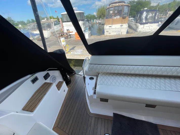  Yacht Photos Pics 2010 Regal 44 Sport Coupe interior with white seating and wooden flooring at a marina.