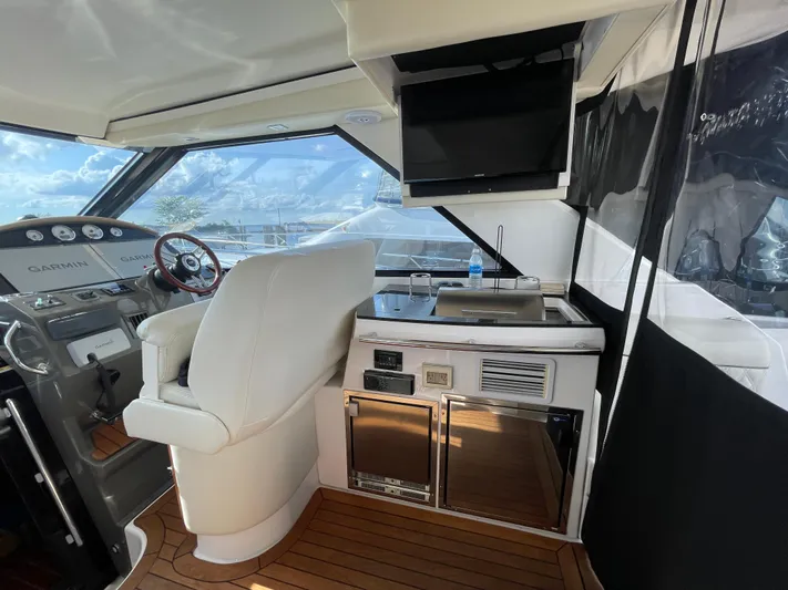  Yacht Photos Pics 2010 Regal 44 Sport Coupe interior with helm, seating, and kitchenette.