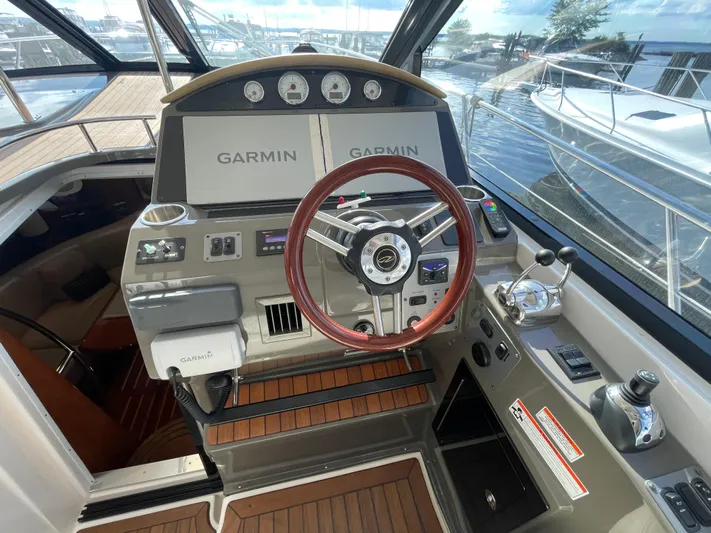  Yacht Photos Pics Cockpit of 2010 Regal 44 Sport Coupe with Garmin navigation system and wooden steering wheel.