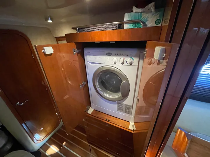  Yacht Photos Pics Laundry area inside 2010 Regal 44 Sport Coupe yacht with wooden cabinetry.