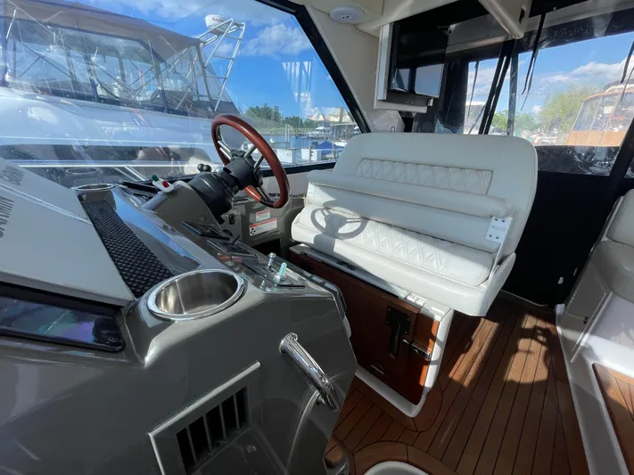  Yacht Photos Pics 2010 Regal 44 Sport Coupe interior with leather seating and wooden steering wheel.