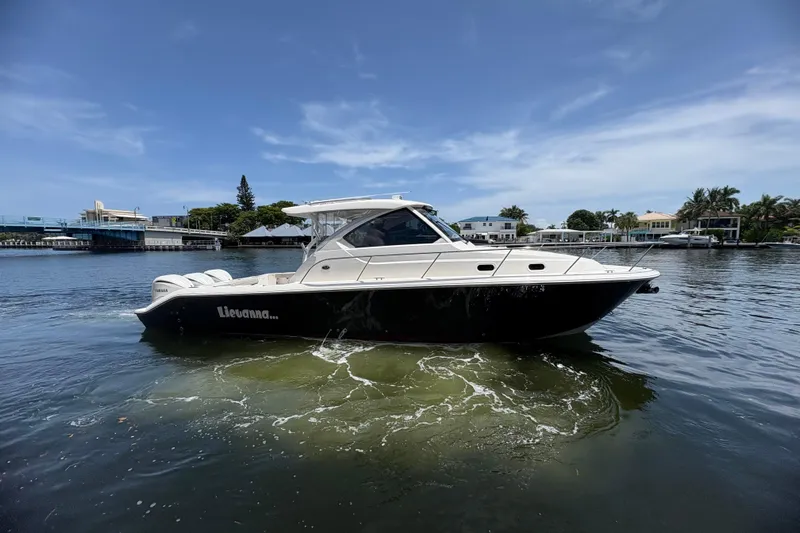 Lieuanna Yacht Photos Pics 2024 Pursuit OS 355 Offshore boat cruising on a calm waterway under a clear blue sky.