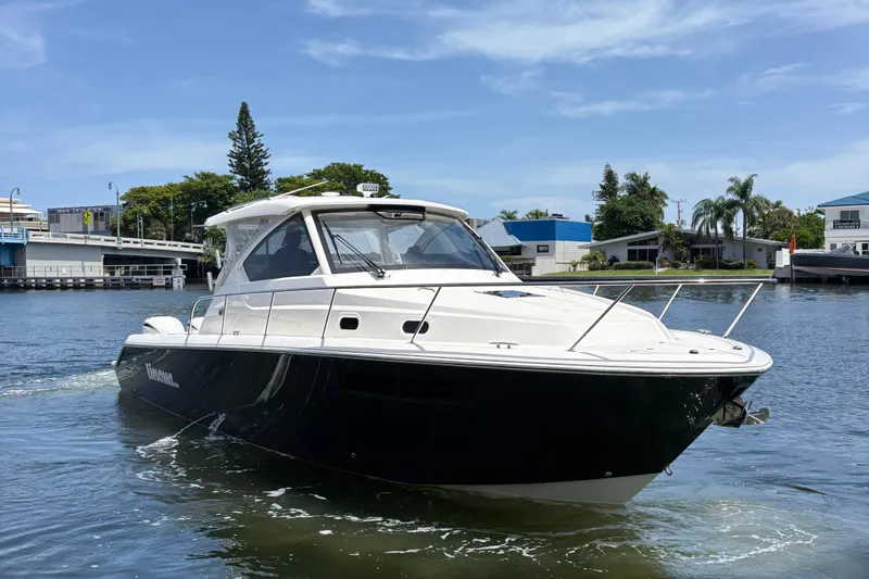 Lieuanna Yacht Photos Pics 2024 Pursuit OS 355 Offshore boat cruising on a sunny day in a marina.