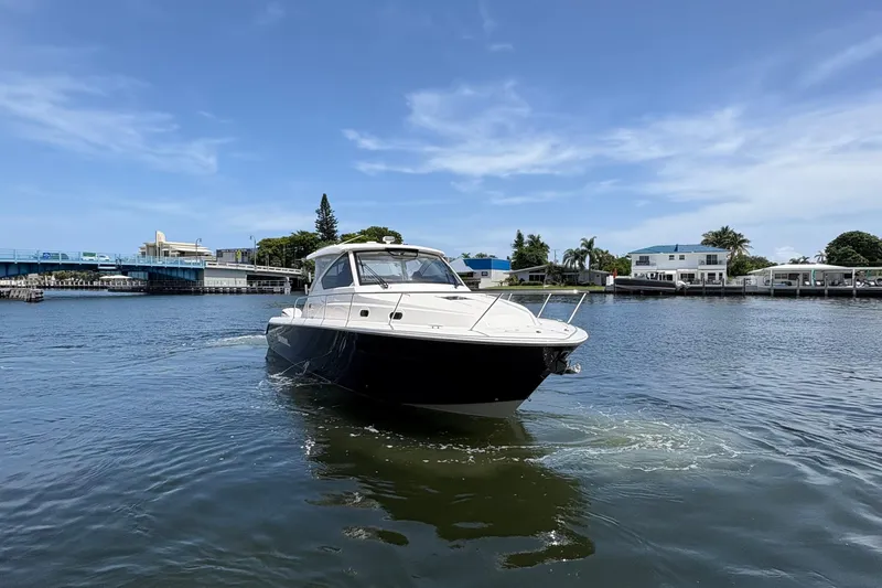 Lieuanna Yacht Photos Pics 2024 Pursuit OS 355 Offshore boat cruising on a sunny day near waterfront homes.