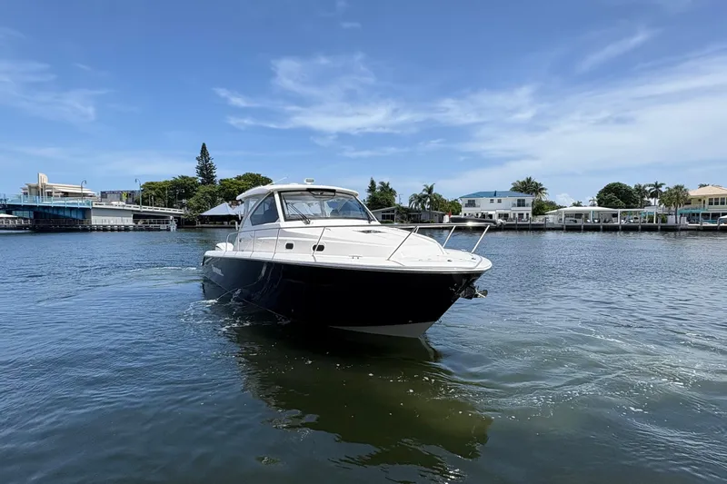Lieuanna Yacht Photos Pics 2024 Pursuit OS 355 Offshore boat cruising on a sunny day near waterfront homes.