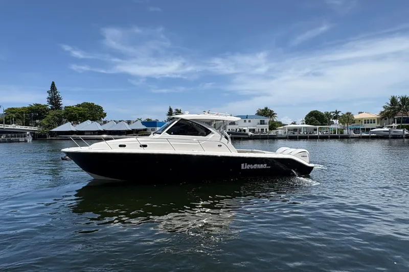 Lieuanna Yacht Photos Pics 2024 Pursuit OS 355 Offshore boat cruising on a sunny day in a scenic waterfront area.
