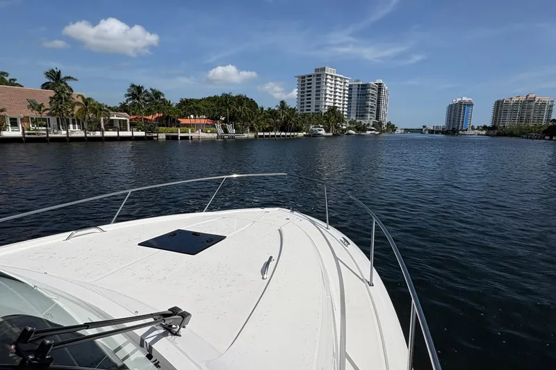 Lieuanna Yacht Photos Pics 2024 Pursuit OS 355 Offshore cruising on a scenic waterway with city skyline views.