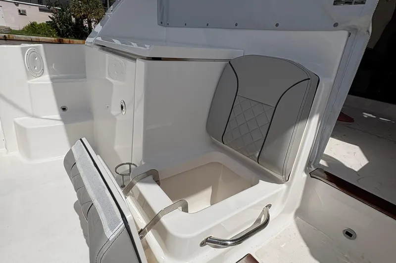 Lieuanna Yacht Photos Pics 2024 Pursuit OS 355 Offshore boat interior with foldable seat and storage compartment.