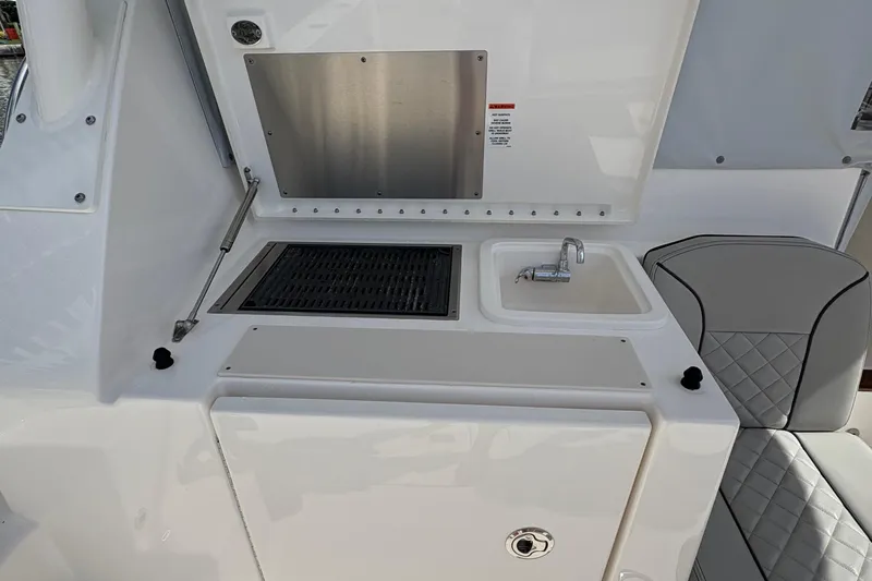 Lieuanna Yacht Photos Pics 2024 Pursuit OS 355 Offshore boat galley with sink, grill, and seating.
