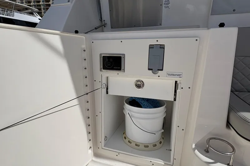 Lieuanna Yacht Photos Pics 2024 Pursuit OS 355 Offshore boat storage compartment with bucket and cleaning supplies.