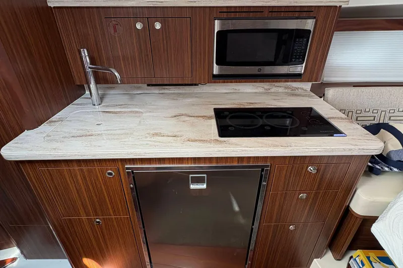 Lieuanna Yacht Photos Pics 2024 Pursuit OS 355 Offshore yacht kitchen with modern appliances and wood cabinetry.