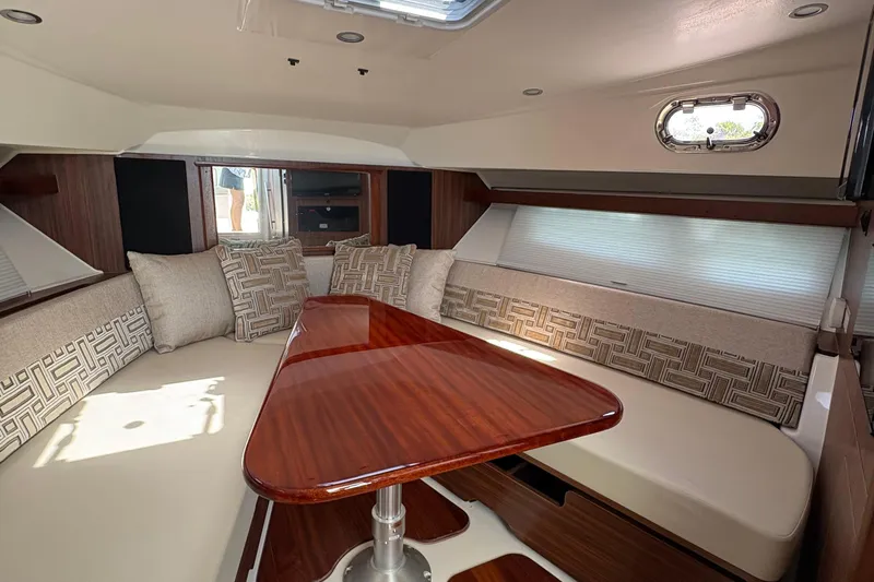 Lieuanna Yacht Photos Pics 2024 Pursuit OS 355 Offshore cabin interior with elegant seating and wooden table.