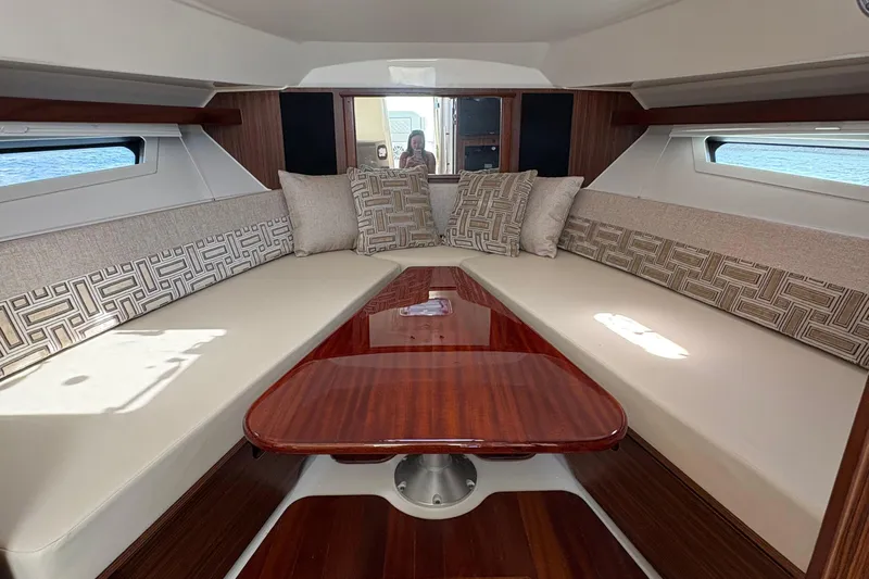 Lieuanna Yacht Photos Pics 2024 Pursuit OS 355 Offshore cabin interior with elegant seating and wooden table.
