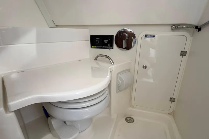 Lieuanna Yacht Photos Pics 2024 Pursuit OS 355 Offshore boat bathroom with compact toilet and storage cabinet.