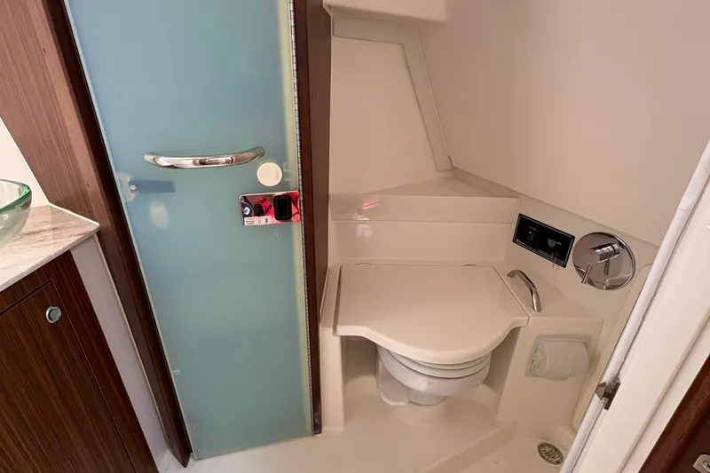 Lieuanna Yacht Photos Pics 2024 Pursuit OS 355 Offshore bathroom with modern fixtures and frosted glass door.