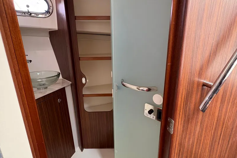 Lieuanna Yacht Photos Pics 2024 Pursuit OS 355 Offshore interior with wooden cabinetry and glass sink.