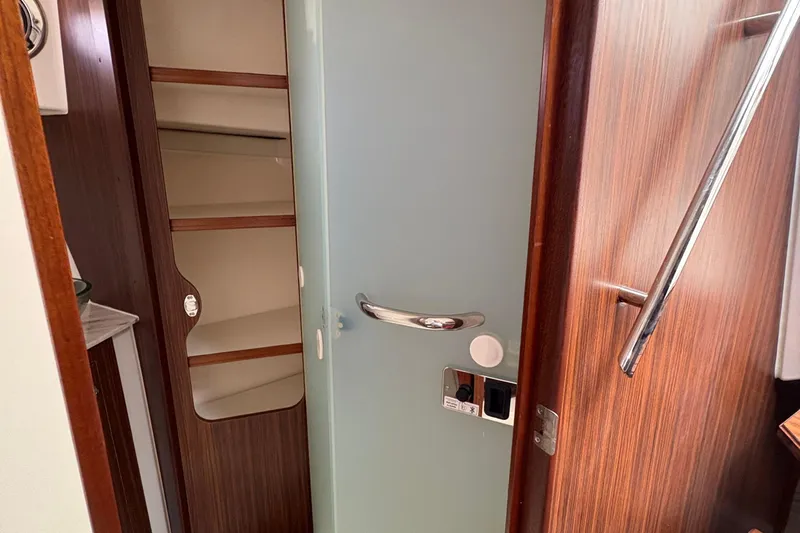 Lieuanna Yacht Photos Pics Interior of 2024 Pursuit OS 355 Offshore boat with wooden cabinetry and frosted glass door.