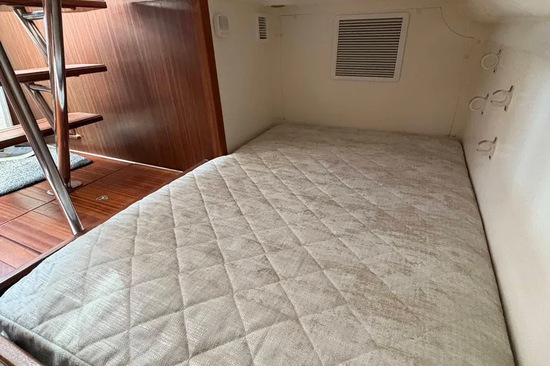 Lieuanna Yacht Photos Pics 2024 Pursuit OS 355 Offshore cabin interior with cozy bed and wooden stairs.