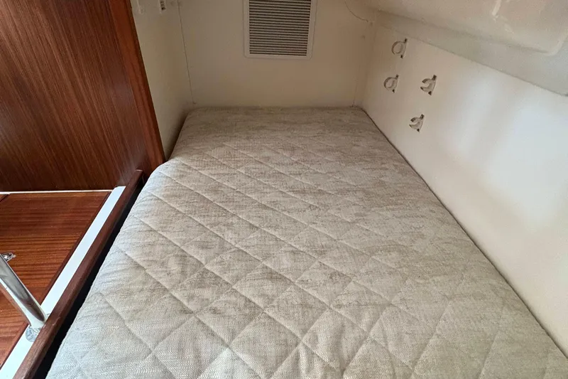 Lieuanna Yacht Photos Pics 2024 Pursuit OS 355 Offshore cabin interior with a comfortable bed and wooden accents.