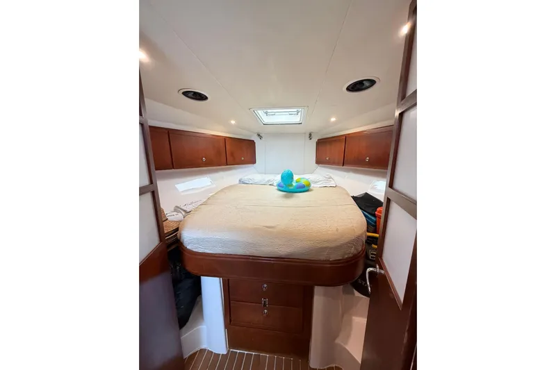  Yacht Photos Pics Cozy cabin interior of 2009 Bertram 390 yacht with bed and storage cabinets.