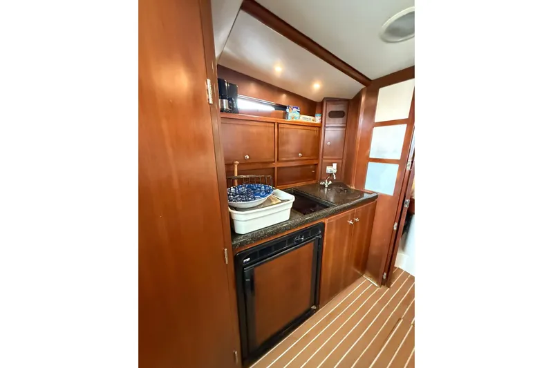  Yacht Photos Pics 2009 Bertram 390 yacht interior kitchen with wooden cabinets and compact appliances.