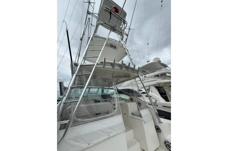  Yacht Photos Pics 2009 Bertram 390 boat with tower, docked under cloudy skies.
