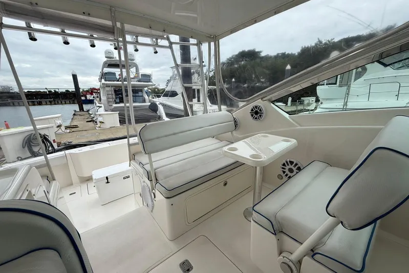  Yacht Photos Pics Interior of a 2009 Bertram 390 yacht with white seating and table, docked at a marina.