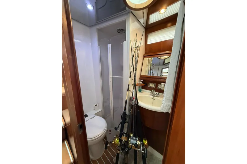  Yacht Photos Pics 2009 Bertram 390 yacht bathroom with fishing rods, sink, and toilet.