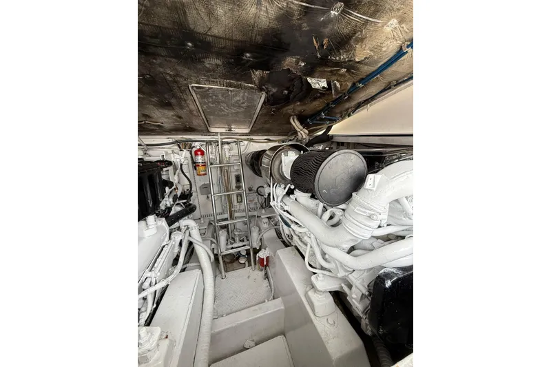  Yacht Photos Pics Engine room of a 2009 Bertram 390 boat, featuring mechanical components and a fire extinguisher.