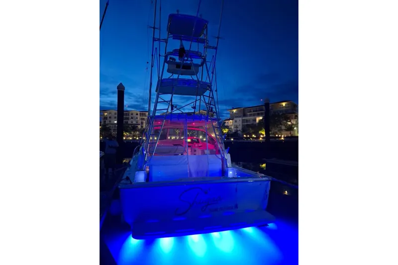  Yacht Photos Pics 2009 Bertram 390 yacht with blue underwater lights at night, docked in a marina.