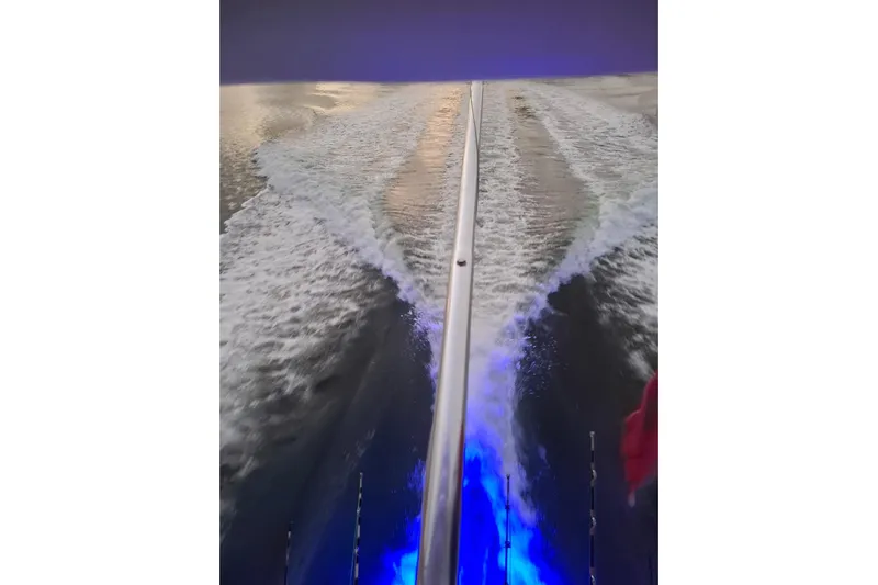  Yacht Photos Pics Wake trail behind a 2009 Bertram 390 boat with blue underwater lights.