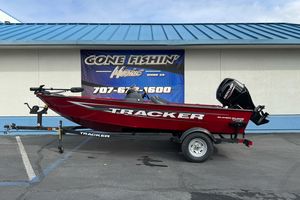2026 Tracker Super Guide V-16 SC boat on trailer, parked outside marine shop.