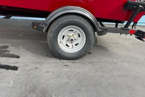 Trailer wheel of 2026 Tracker Super Guide V-16 SC boat on concrete surface.