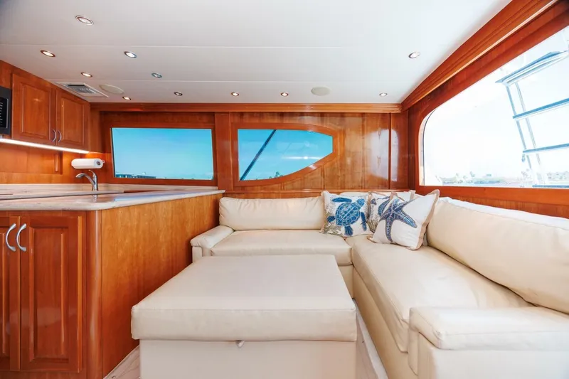 Loca Louise Yacht Photos Pics Luxurious interior of 2002 Hatteras 50 Convertible yacht with plush seating and wooden cabinetry.