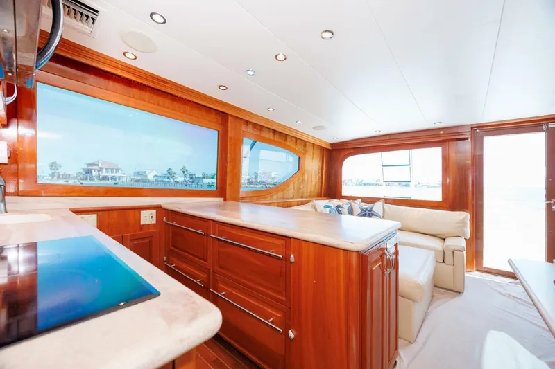 Loca Louise Yacht Photos Pics Luxurious interior of 2002 Hatteras 50 Convertible yacht with wood finishes and large windows.